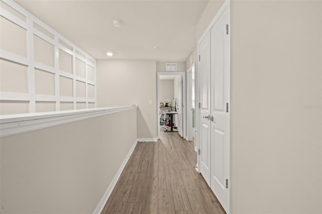 hall with baseboards and wood finished floors