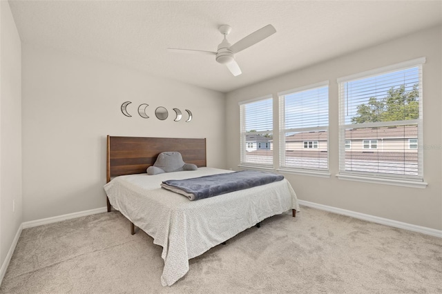 carpeted bedroom featuring baseboards and a ceiling fan