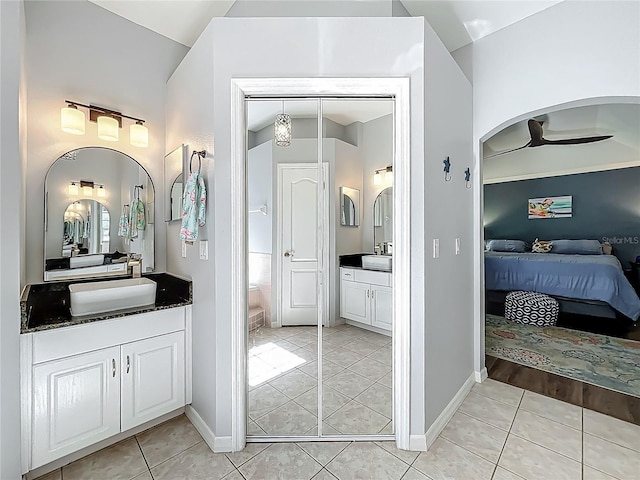 ensuite bathroom with two vanities, a sink, tile patterned flooring, and ensuite bath