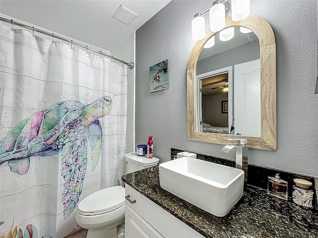 full bathroom with a textured wall, vanity, toilet, a shower with shower curtain, and visible vents