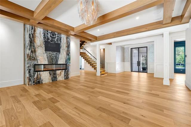 5525 Isleworth Country Club Dr, Windermere, FL 34786 - unfurnished living room featuring a large fireplace, stairway, beam ceiling, wood finished floors, and a chandelier