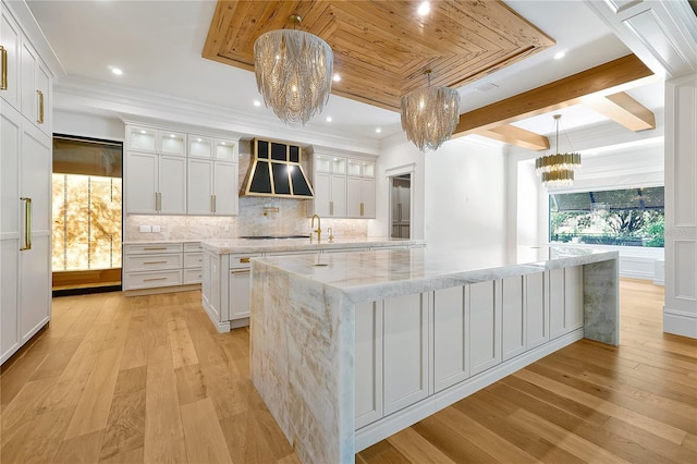 5525 Isleworth Country Club Dr, Windermere, FL 34786 - kitchen with a chandelier, a spacious island, wall chimney range hood, decorative backsplash, and light wood-type flooring