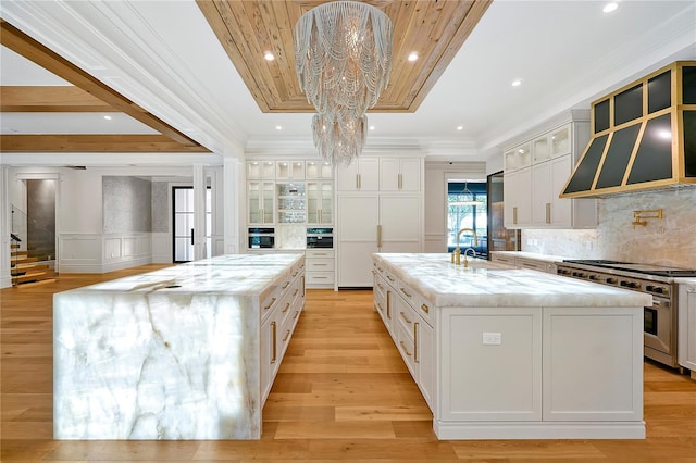 5525 Isleworth Country Club Dr, Windermere, FL 34786 - kitchen with a large island, stainless steel appliances, crown molding, white cabinetry, and a decorative wall