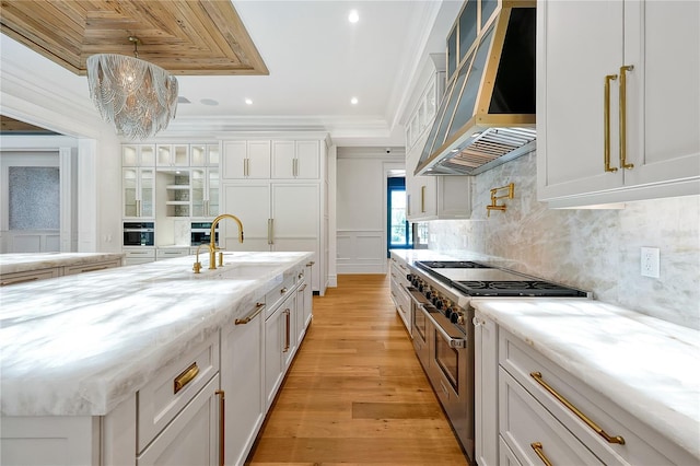 5525 Isleworth Country Club Dr, Windermere, FL 34786 - kitchen featuring wall chimney exhaust hood, double oven range, a sink, white cabinets, and tasteful backsplash