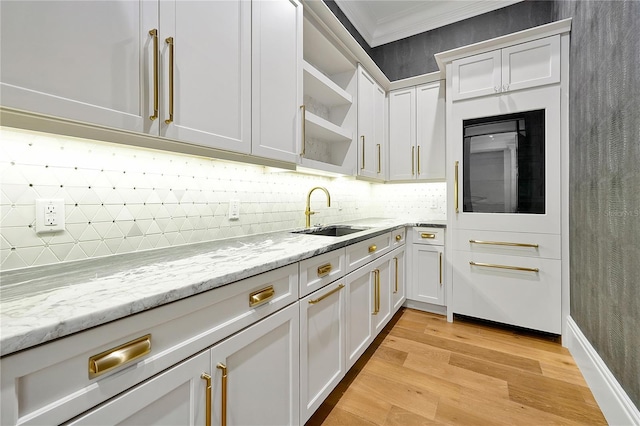 5525 Isleworth Country Club Dr, Windermere, FL 34786 - kitchen featuring a sink, crown molding, tasteful backsplash, white cabinetry, and light wood finished floors