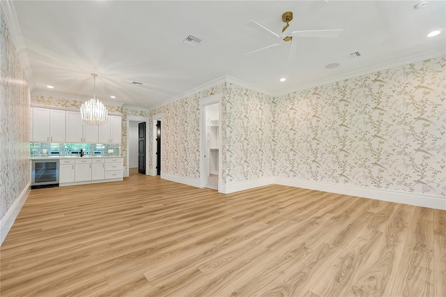 5525 Isleworth Country Club Dr, Windermere, FL 34786 - unfurnished living room featuring beverage cooler, a chandelier, crown molding, light wood-style floors, and ceiling fan