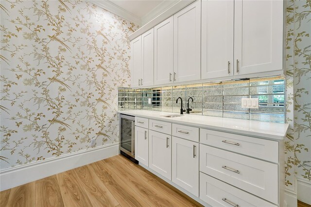 5525 Isleworth Country Club Dr, Windermere, FL 34786 - indoor wet bar featuring beverage cooler, wallpapered walls, light wood-type flooring, ornamental molding, and baseboards