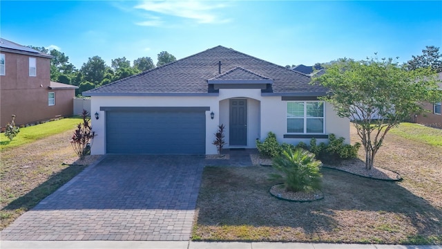 ranch-style house with a front lawn, stucco siding, a shingled roof, an attached garage, and driveway