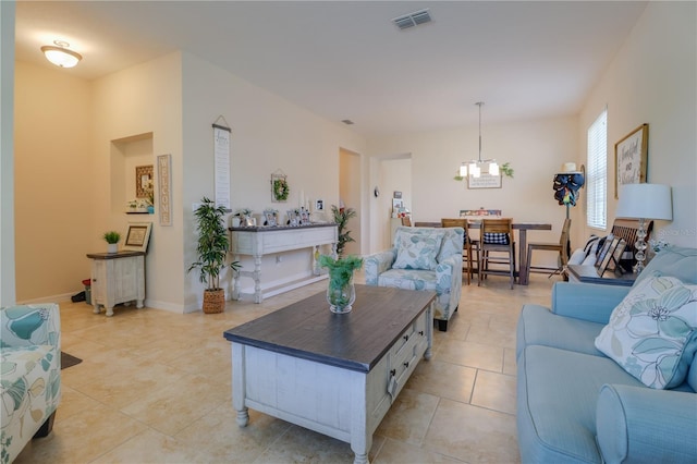 living room featuring light tile patterned flooring, a chandelier, and visible vents