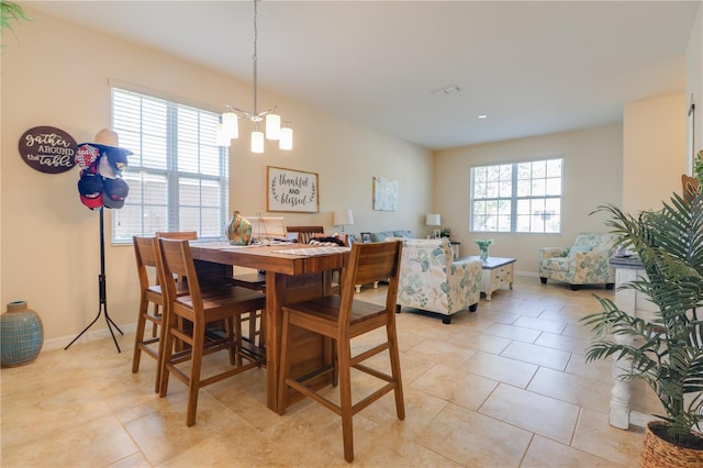 dining room featuring baseboards, an inviting chandelier, and light tile patterned floors