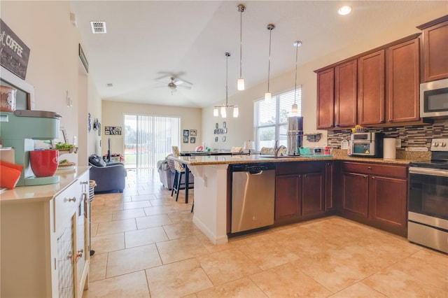 kitchen featuring plenty of natural light, a ceiling fan, visible vents, a peninsula, and stainless steel appliances