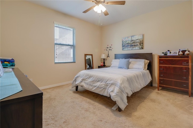 bedroom featuring baseboards, light carpet, and ceiling fan