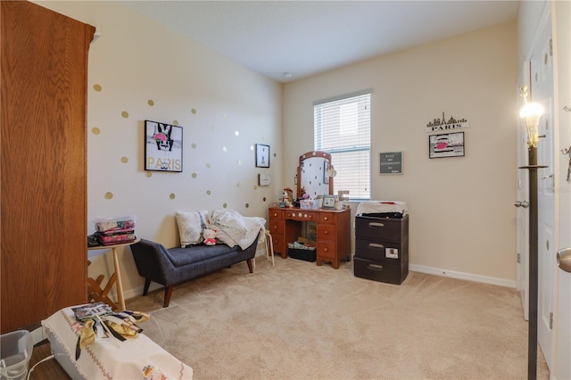 sitting room with baseboards and light carpet