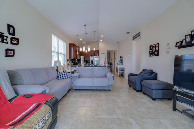 living room featuring visible vents, a notable chandelier, light tile patterned floors, and vaulted ceiling
