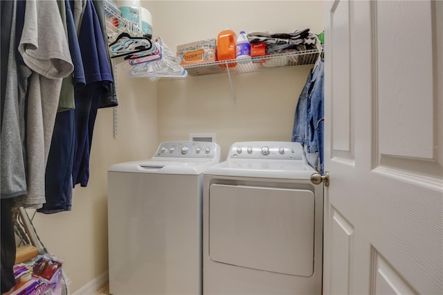 clothes washing area featuring laundry area and washer and clothes dryer