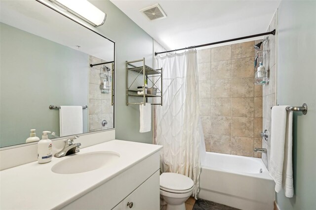 full bath featuring visible vents, shower / tub combo, tile patterned floors, vanity, and toilet