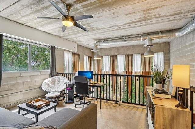 sunroom featuring concrete floors and concrete block wall