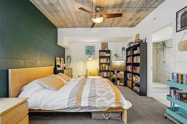 bedroom featuring ensuite bathroom, ceiling fan, and carpet