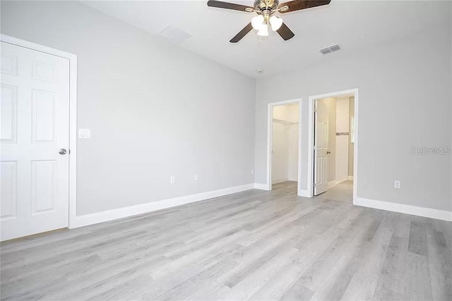 8312 N Pitcairn Way, Citrus Springs, FL 34434 - unfurnished bedroom featuring light wood-style flooring, baseboards, a spacious closet, and a ceiling fan