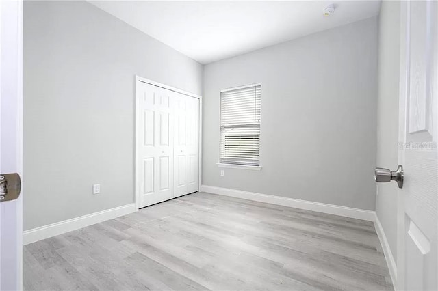 8312 N Pitcairn Way, Citrus Springs, FL 34434 - unfurnished bedroom featuring wood finished floors, a closet, and baseboards