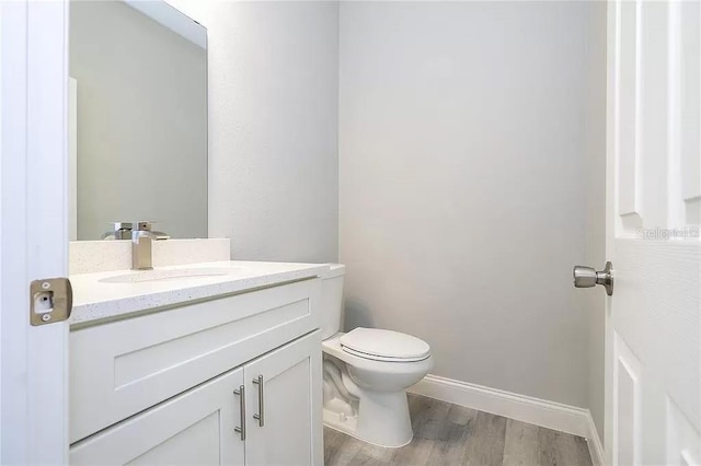 8312 N Pitcairn Way, Citrus Springs, FL 34434 - half bathroom with vanity, toilet, wood finished floors, and baseboards