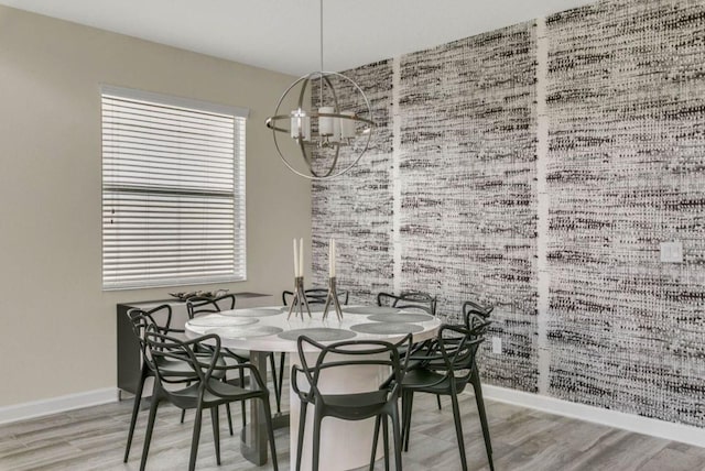 dining area with an inviting chandelier, baseboards, and wood finished floors