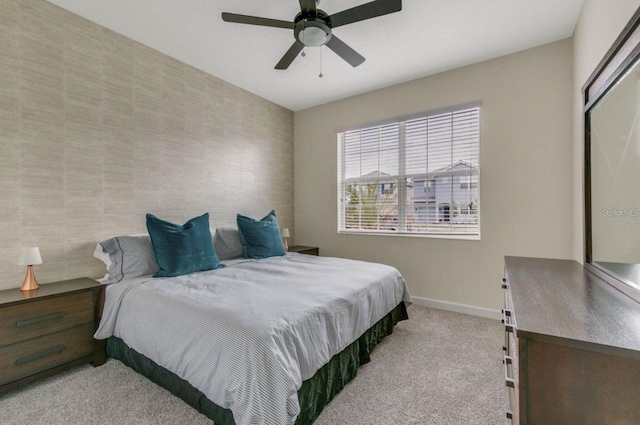 carpeted bedroom featuring baseboards and ceiling fan