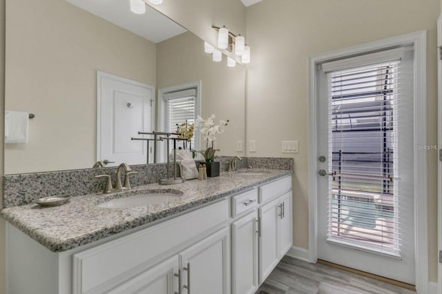 bathroom with a healthy amount of sunlight, a sink, and wood finished floors