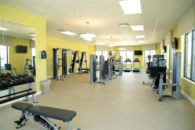 gym featuring baseboards, visible vents, and a wealth of natural light