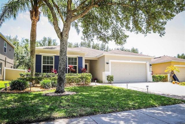 single story home with concrete driveway, an attached garage, a front lawn, and stucco siding