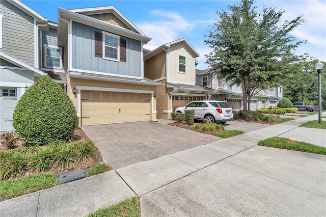 multi unit property with board and batten siding, decorative driveway, and an attached garage