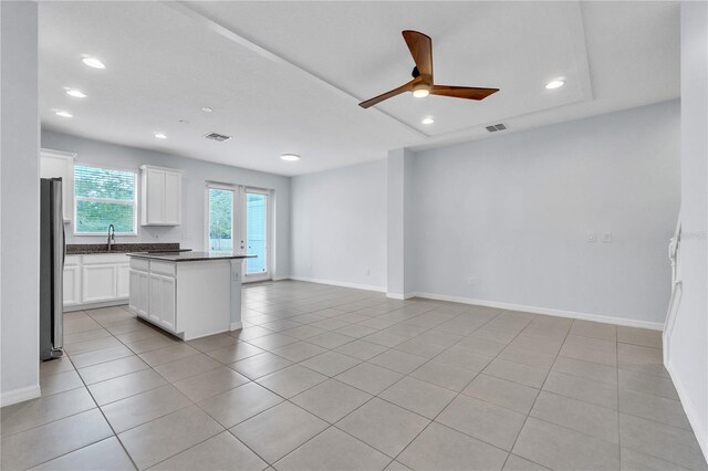 kitchen with ceiling fan, visible vents, dark countertops, freestanding refrigerator, and open floor plan