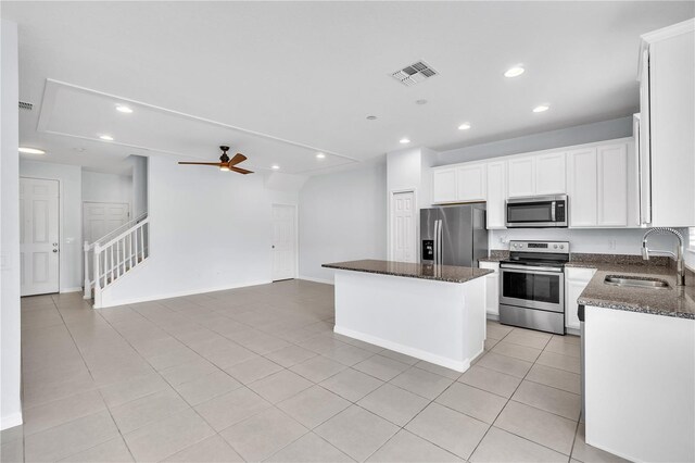 kitchen with a ceiling fan, a kitchen island, recessed lighting, a sink, and stainless steel appliances