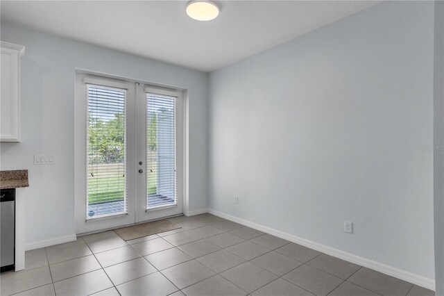 unfurnished room with french doors, baseboards, and light tile patterned floors