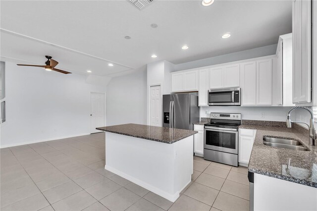 kitchen with a ceiling fan, a center island, a sink, stainless steel appliances, and white cabinetry