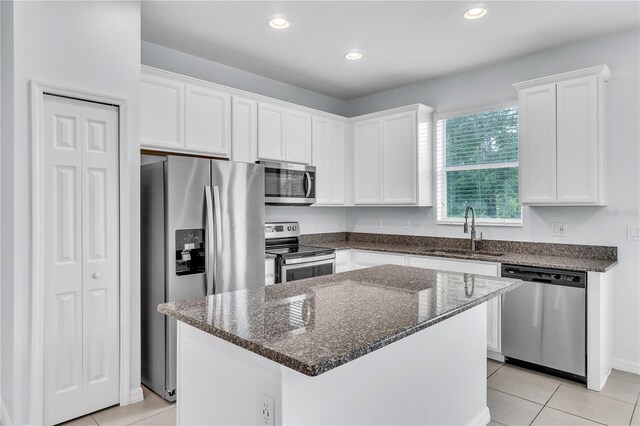 kitchen with a sink, appliances with stainless steel finishes, and white cabinetry