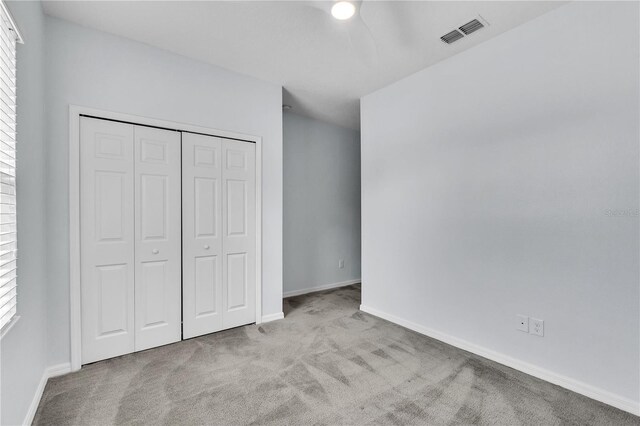 unfurnished bedroom featuring a closet, baseboards, carpet flooring, and visible vents
