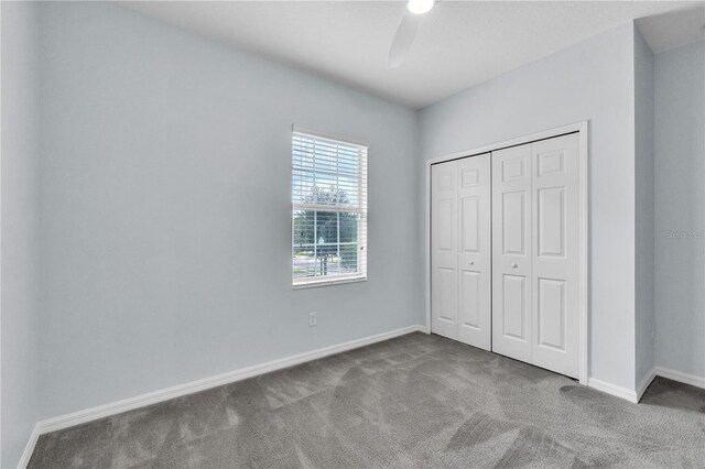 unfurnished bedroom featuring carpet floors, a ceiling fan, baseboards, and a closet