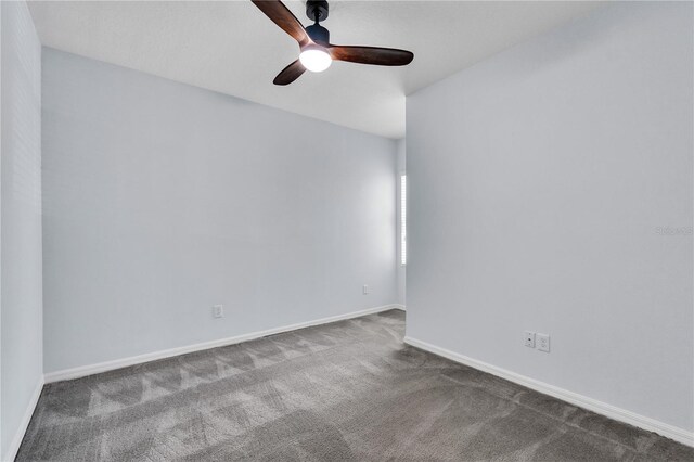 carpeted spare room with baseboards and a ceiling fan