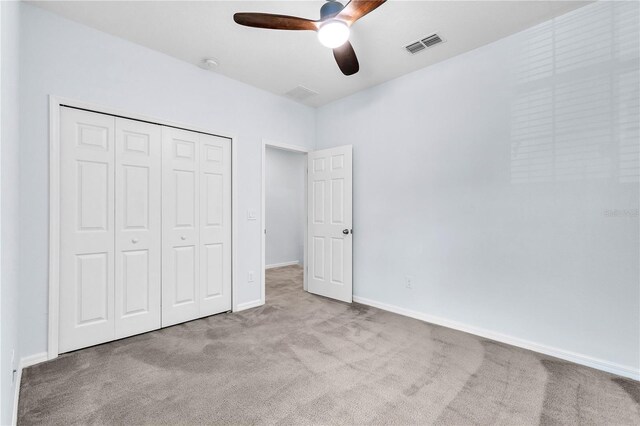 unfurnished bedroom featuring visible vents, carpet flooring, baseboards, and a closet