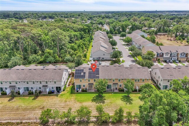 drone / aerial view with a wooded view and a residential view