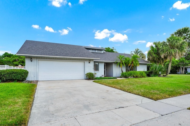 3379 Monika Cir, Orlando, FL 32812 - view of front of property featuring board and batten siding, a front lawn, concrete driveway, an attached garage, and a shingled roof