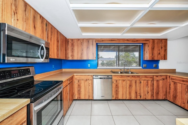 3379 Monika Cir, Orlando, FL 32812 - kitchen with brown cabinets, light tile patterned flooring, a sink, light countertops, and stainless steel appliances