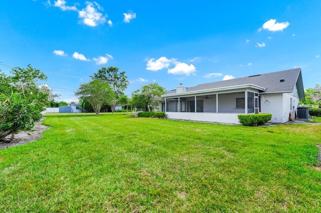3379 Monika Cir, Orlando, FL 32812 - rear view of house featuring a sunroom, a ceiling fan, a lawn, and central air condition unit
