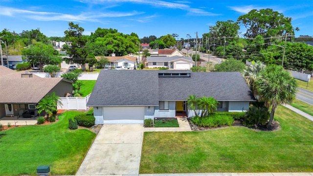 3379 Monika Cir, Orlando, FL 32812 - ranch-style house featuring a front lawn, fence, roof with shingles, an attached garage, and driveway