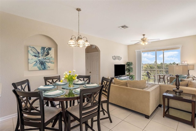 dining room featuring arched walkways, visible vents, light tile patterned flooring, and ceiling fan with notable chandelier