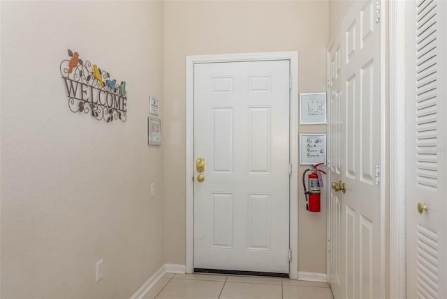 entryway featuring baseboards and light tile patterned floors