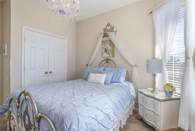 bedroom featuring carpet flooring, a closet, and a notable chandelier