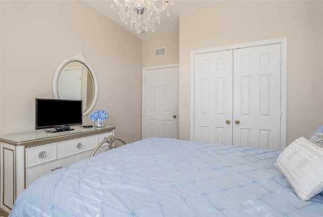 bedroom featuring a closet, an inviting chandelier, and visible vents
