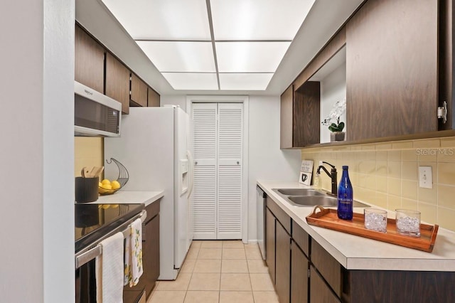 206 Diamond Cv Unit 106, Casselberry, FL 32707 - kitchen featuring dark brown cabinetry, light countertops, tasteful backsplash, a sink, and stainless steel appliances